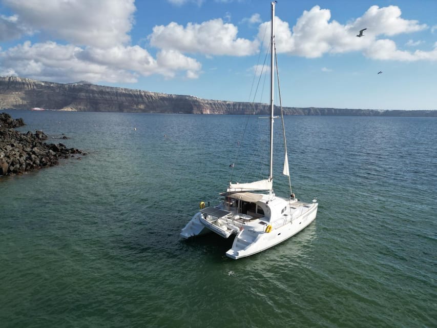 Santorini: Catamaran Cruise with Greek BBQ and Drinks - White Beach and the sea caves