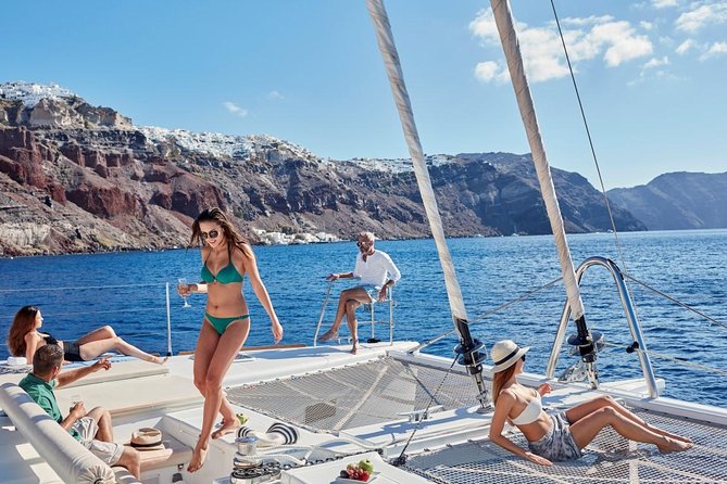 Santorini Sunset Luxury Sailing Catamaran Cruise with BBQ, drinks, transfer - Red Beach, where volcanic color meets clear water